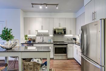 a modern kitchen with stainless steel appliances and white cabinets